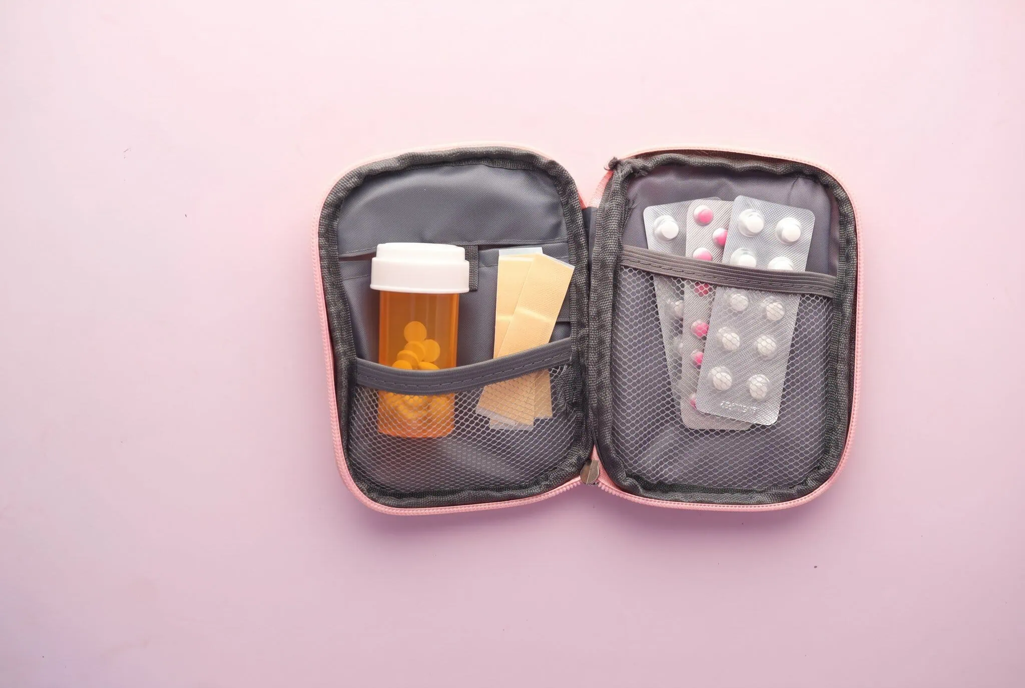 Reiseapotheke: Was gehört rein? Komplette Checkliste für 2026 1 Geöffnete Reiseapotheke mit Medikamenten und Pflastern