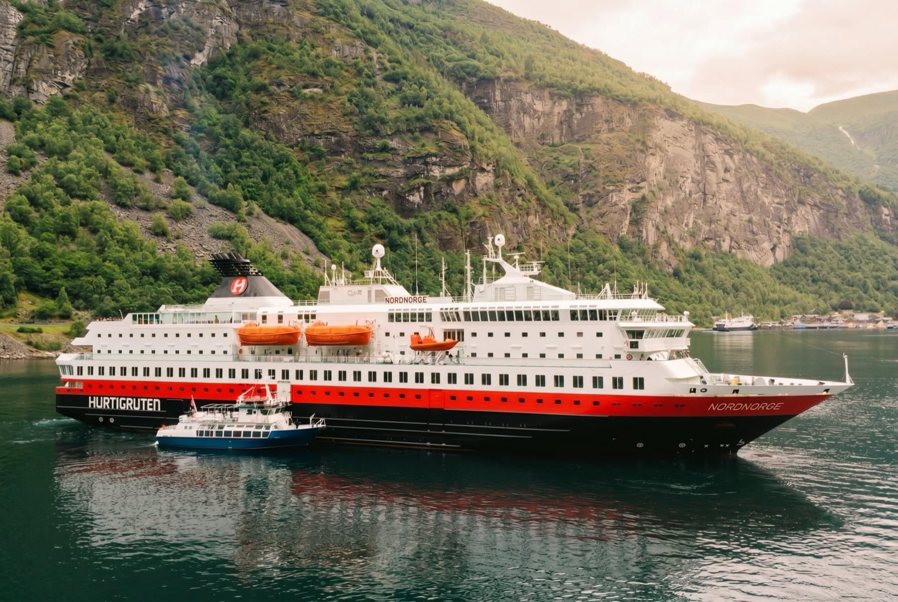 Hurtigruten: 8 lucruri de știut despre croaziera pe coasta Norvegiei în 2026 1 Nava Hurtigruten de-a lungul coastei norvegiene