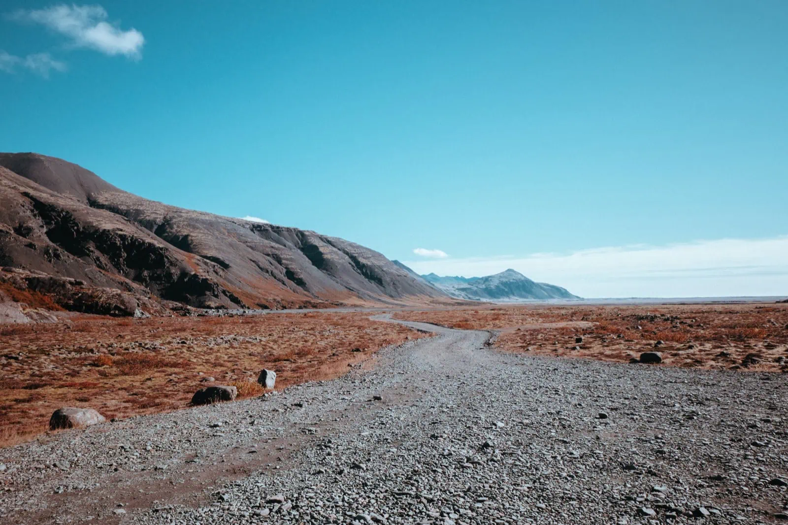 Cómo ahorrar en el alquiler de coches: 15 trucos para alquilar más barato en 2026 5 Camino de grava hacia las montañas en Islandia