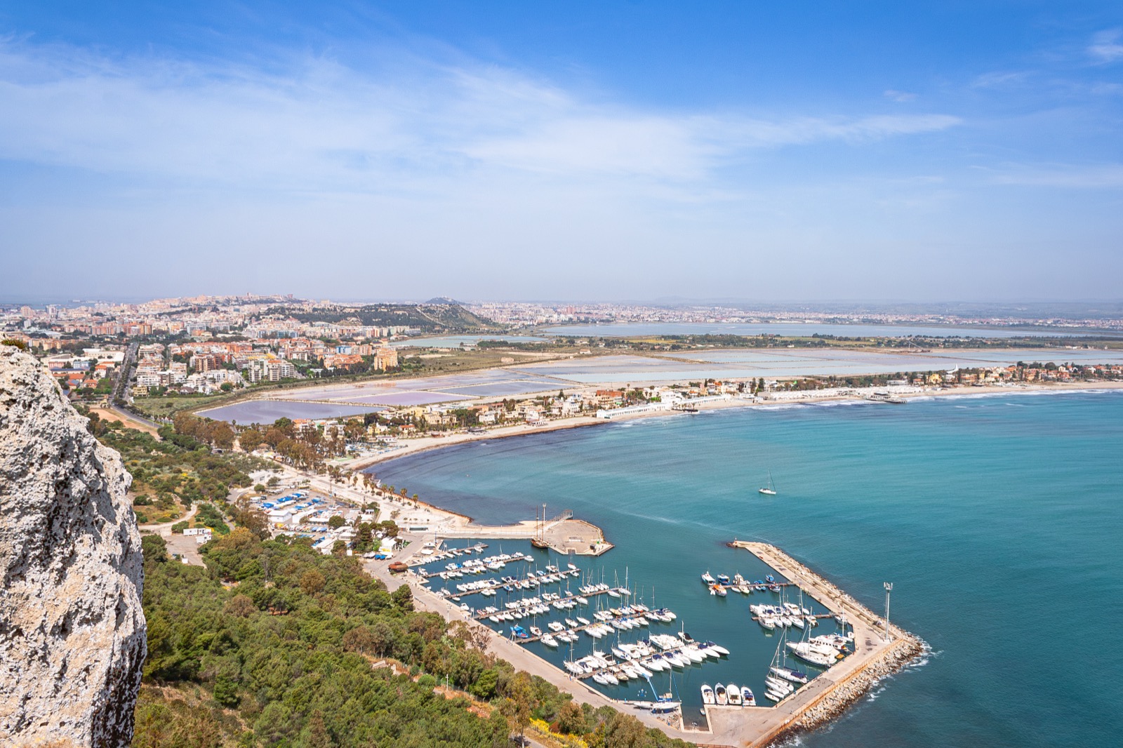 Pohled na Cagliari, přístav a pláž Poetto se slanisky