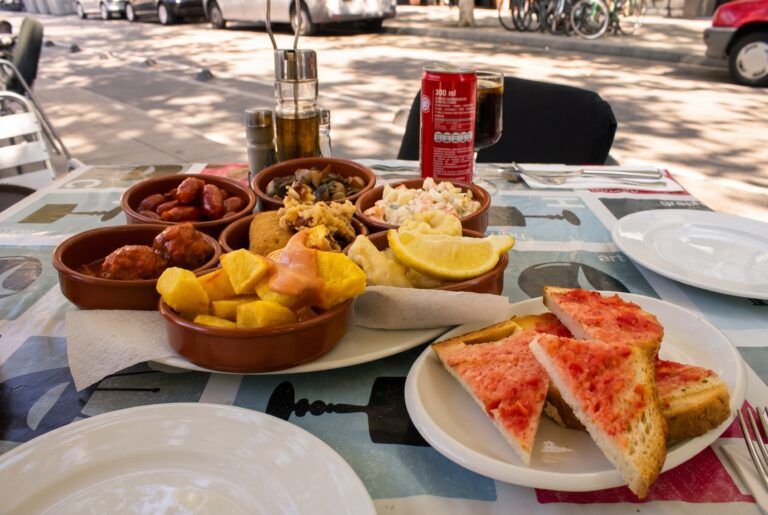 Pult španělského tapas baru plný talířků s tapas