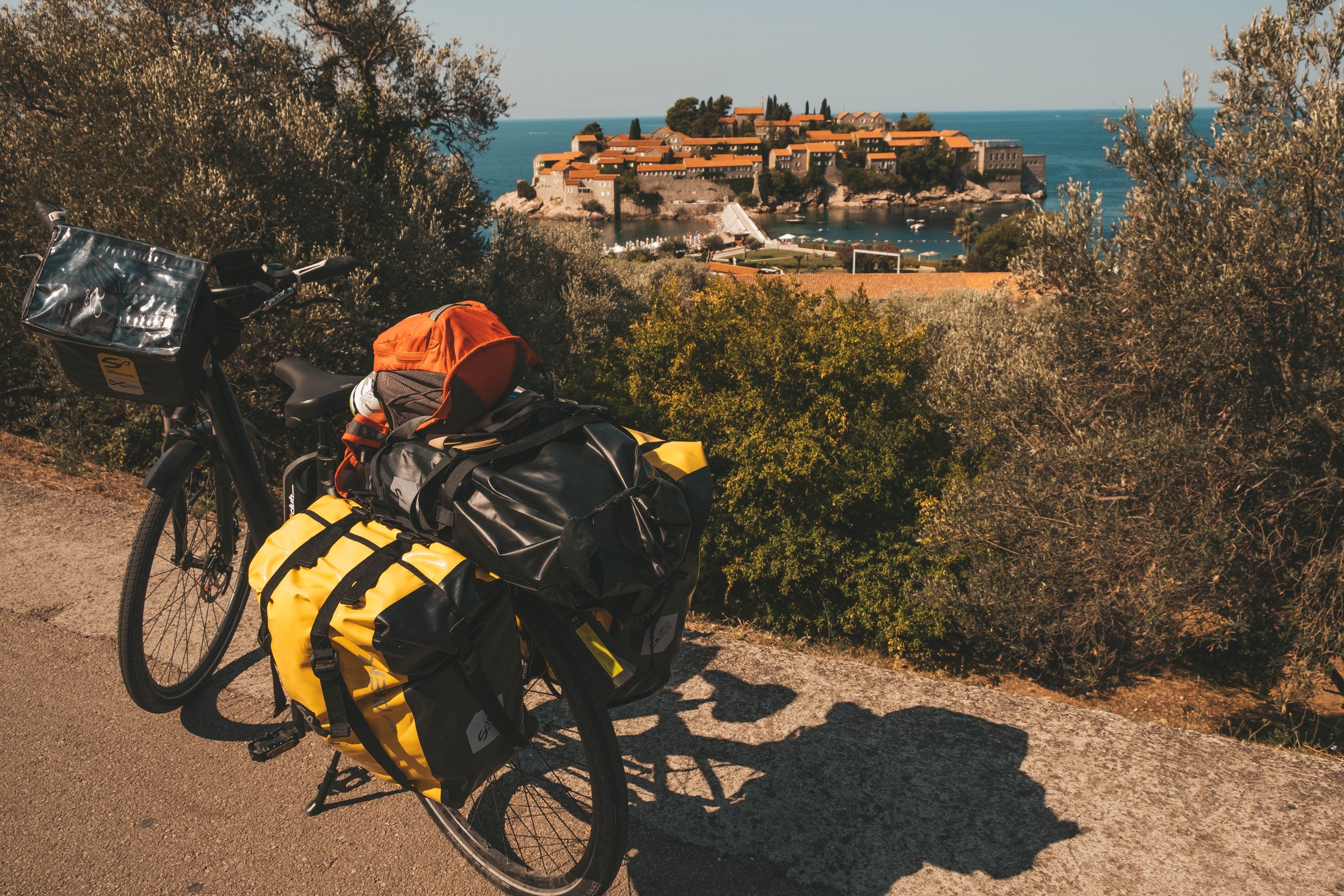 Sveti Stefan, Černá Hora: 10 tipů na nejfotogeničtější ostrov Jadranu 6 Naložené cestovní kolo s výhledem na ostrov Sveti Stefan