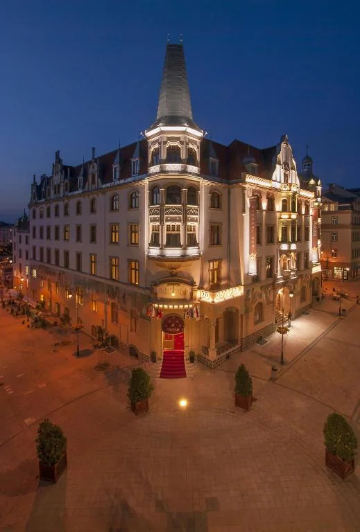 Illuminated Art Nouveau facade of the Grandhotel Ambassador Národní dům in the evening