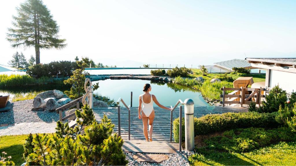 Wellness hotely v Rakousku: 12 míst, kam se budete vracet rok co rok 11 Žena u přírodního bazénu Mountain Resort Feuerberg nad oblaky na Gerlitzen Alpe
