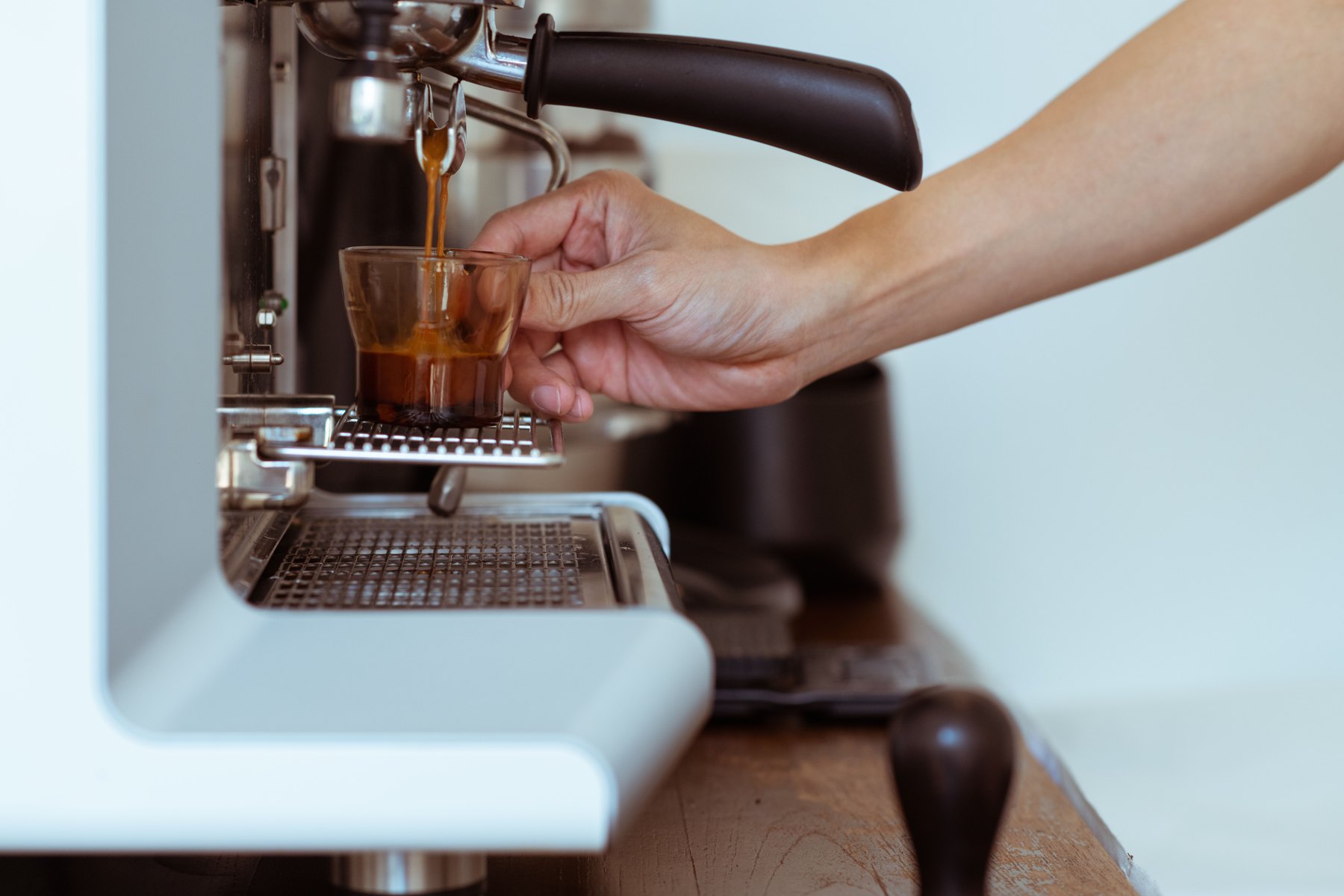 Cele mai bune cafenele din Londra: 18 recomandări pentru cafea de specialitate în 2026 2 Un barista preparând espresso la mașina cu pârghie