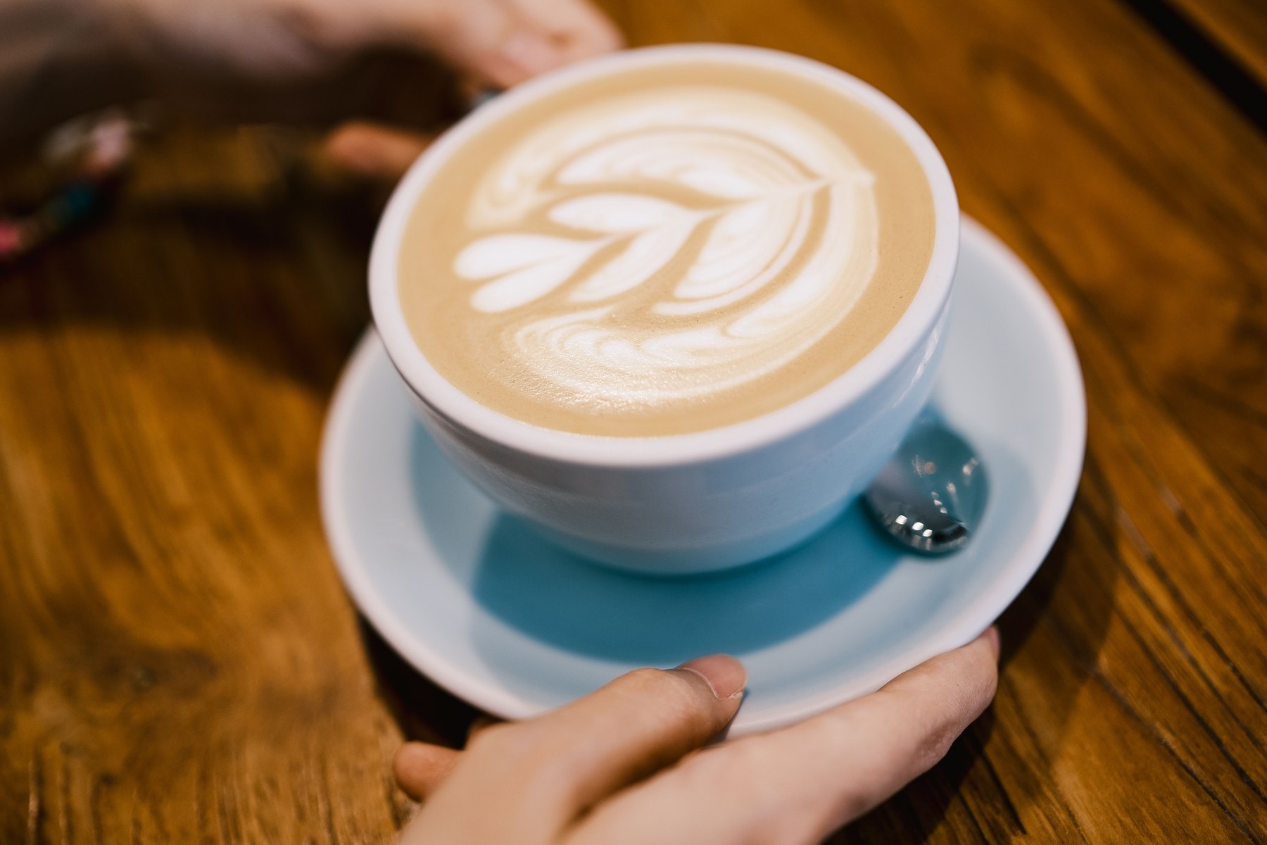 Cele mai bune cafenele din Londra: 18 recomandări pentru cafea de specialitate în 2026 23 Ceașcă de cappuccino cu latte art ținută în mână