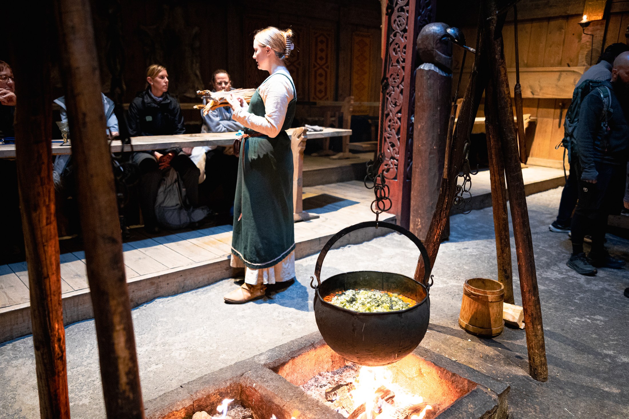 Lofotr Viking Museum: 6 věcí, které musíš vědět 115 Kotlík nad ohněm a průvodkyně v dobovém vikingském kostýmu v Lofotr