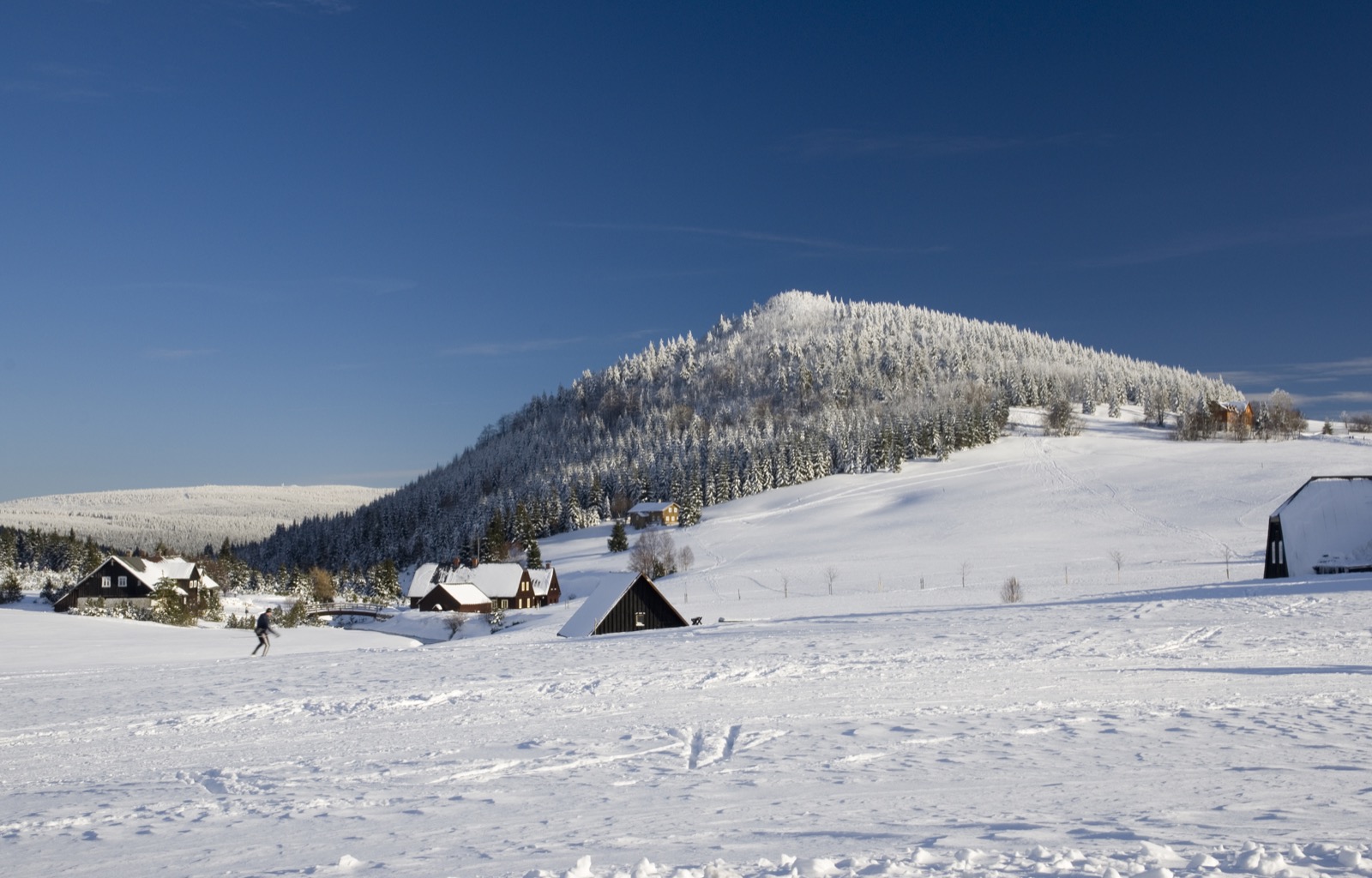 Qué ver en Bohemia del Norte: 15 ideas de rocas a lagos 2026 11 La aldea de Jizerka bajo el nevado Bukovec en los montes de Jizera (Foto: Wikimedia Commons, CC BY-SA)