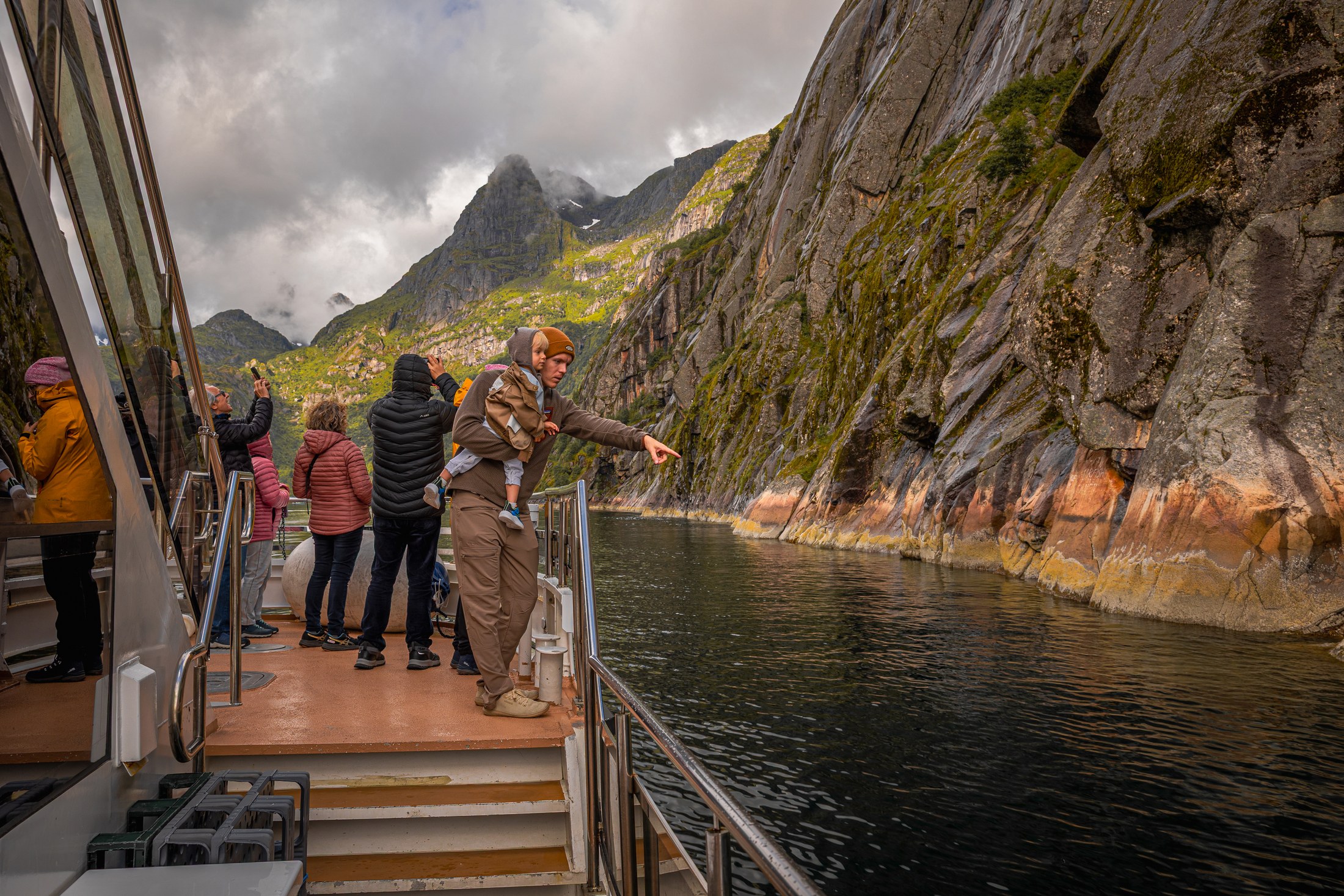 Trollfjord Norge: Båttur på Lofoten i 2026 4 Passasjerer på dekk beundrer Trollfjordens bratte fjellvegger