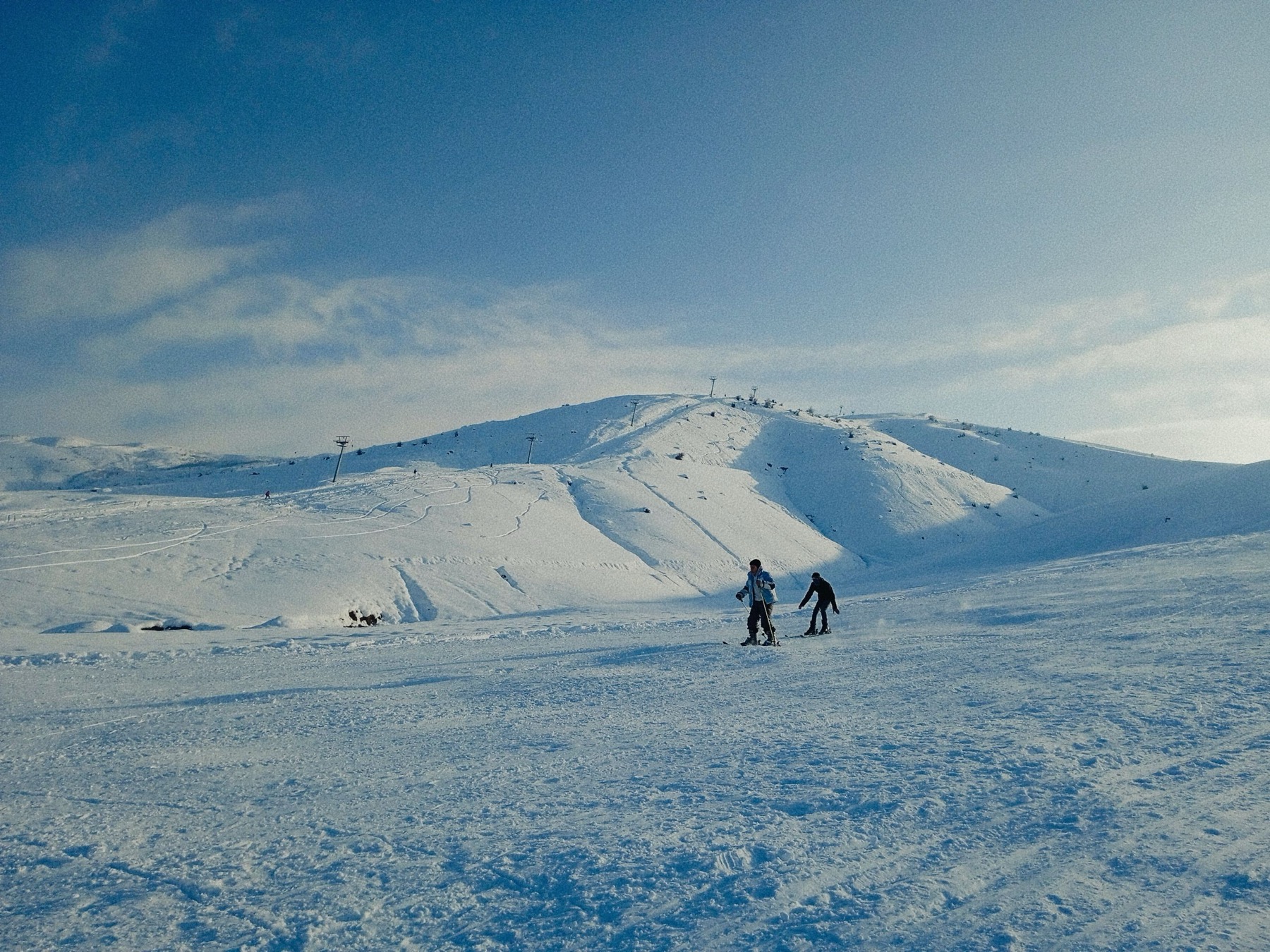Skiing in Bulgaria in 2026: Bansko, Borovets, or Pamporovo? 12 Skiers on the slope on a sunny winter day
