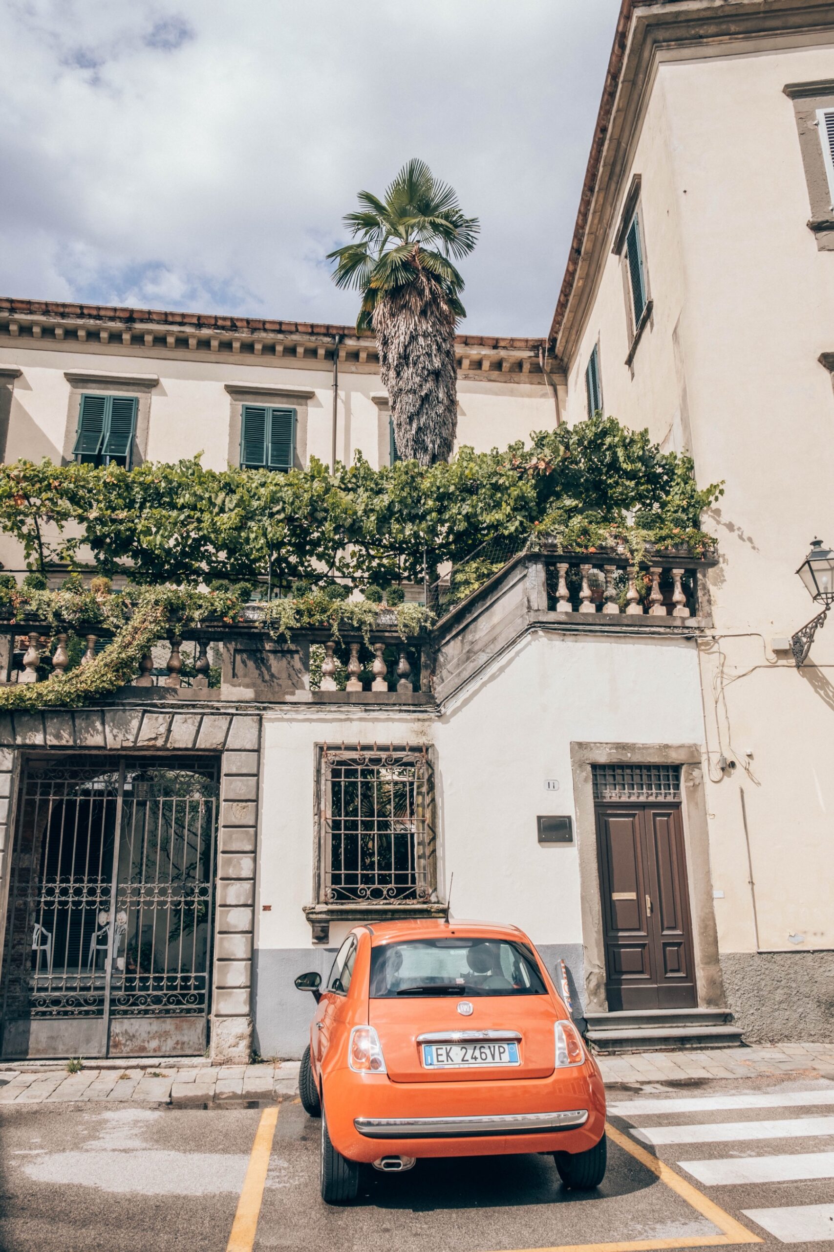 Lucca, Itálie: 22 tipů, co vidět a proč objet hradby na kole 2 Ulice v Lucce s oranžovou Fiat 500 pod popínavou zelení