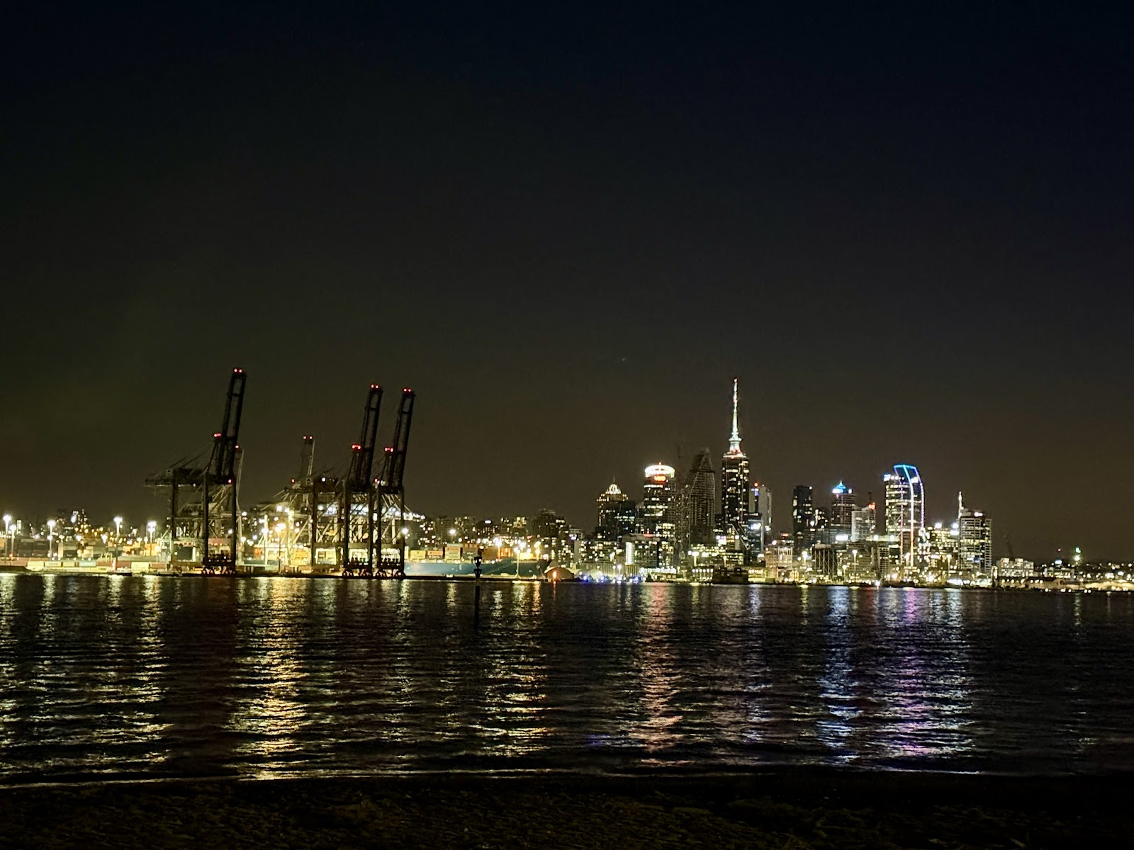 Wo übernachten in Auckland Neuseeland: 18 Hotels 2026 1 Nachtpanorama von Auckland mit Sky Tower und Hafenkränen, die sich in der Bucht spiegeln